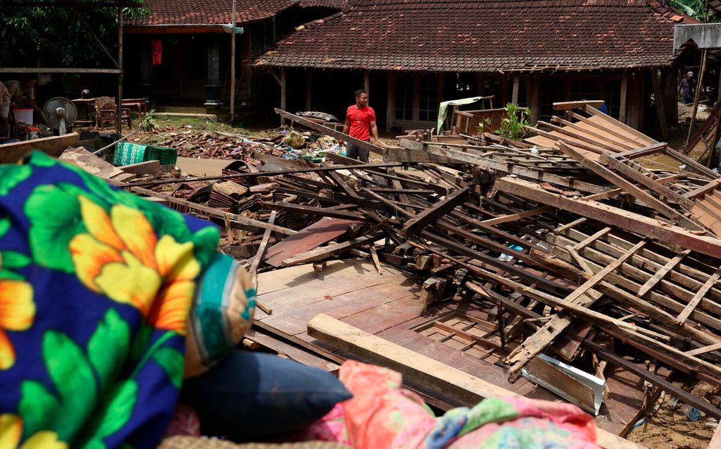 Warga berada di antara salah satu rumah yang roboh setelah banjir bandang menerjang Desa Sinomwidodo, Kecamatan Tambakromo, Kabupaten Pati, Jawa Tengah, Kamis (1/12/2022). 