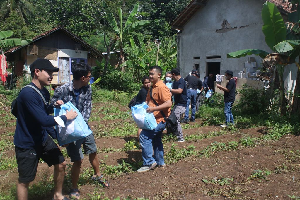 Sejumlah karyawan Kompas Gramedia dan sukarelawan menyalurkan bantuan di Kampung Sedong Kulon, Kelurahan Bojongherang, Kecamatan Cianjur, Kabupaten Cianjur, Jawa Barat, Sabtu (21/1/2023).