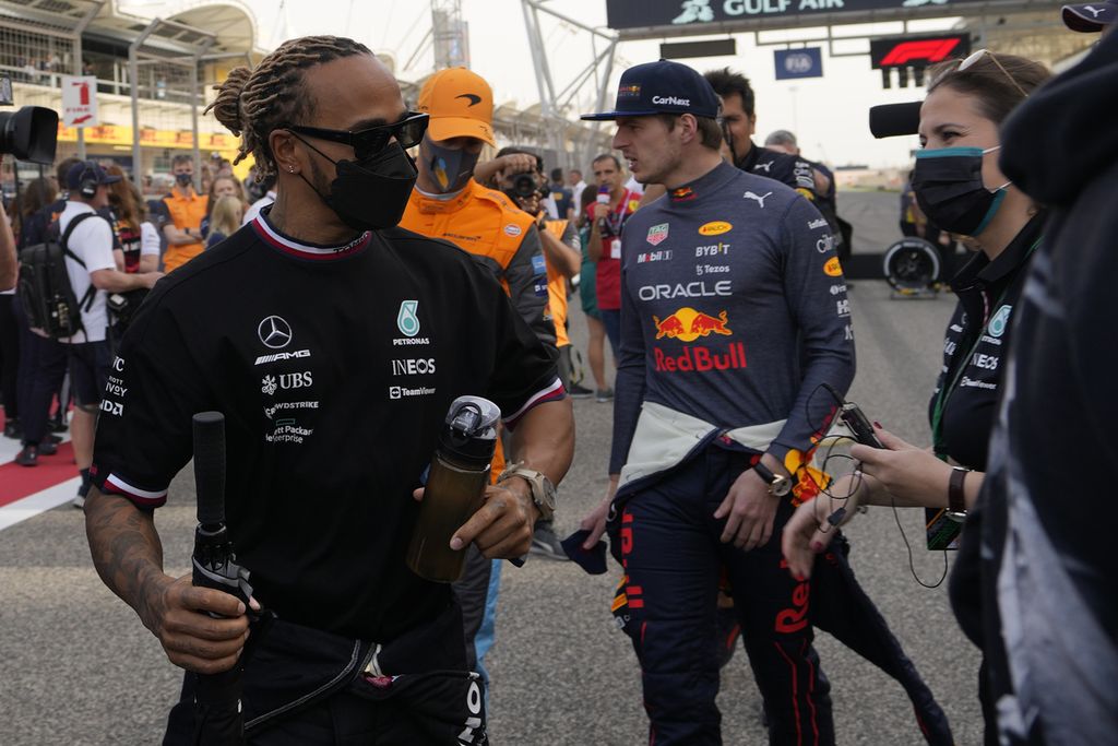 Pebalap Mercedes Lewis Hamilton (kiri) dan pebalap Red Bull Max Verstappen (kedua dari kana) mengikuti parade pebalap jelang Grand Prix Formula 1 Bahrain di Sirkuit Sakhir, Bahrain, 20 Maret 2022.