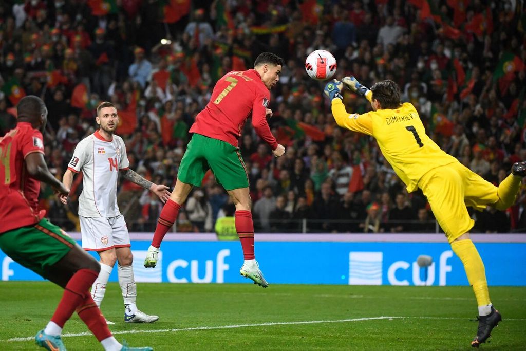 Pemain timnas Portugal, Cristiano Ronaldo, berebut bola dengan kiper Macedonia Utara, Stole Dimitrievski, pada laga pertama final penyisihan Piala Dunia di Stadion Dragao, Porto, Portugal, Rabu (30/3/2022) dini hari WIB. Portugal menang dengan skor 2-0.
