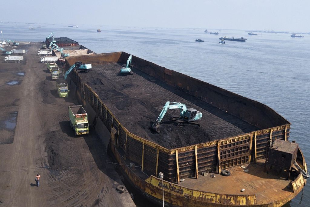 Ilustrasi pemanfaatan sumber energi kotor batubara. Alat berat memindahkan batubara yang didatangkan dari Kalimantan dari dalam tongkang ke atas truk di Pelabuhan KCN Marunda, Jakarta Utara, awal Januari 2022.