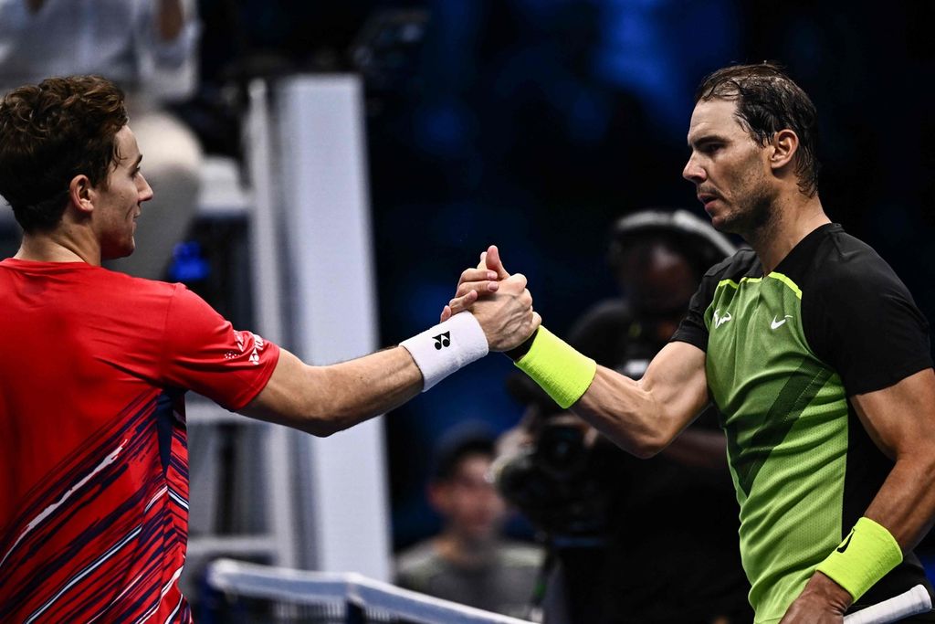 Petenis Norwegia Casper Ruud (kiri) dan petenis Spanyol Rafael Nadal bersalaman setelah pertandingan terakhir babak grup Final ATP di Turin, Italia, Kamis (17/11/2022). Nadal mengalahkan Ruud, 7-5, 7-5, namun gagal maju ke babak semifinal Final ATP.