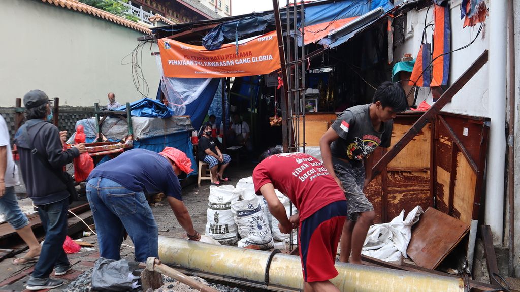 Pekerja membangun tiang di bagian muka Gang Gloria di Kelurahan Glodok, Jakarta Barat, yang tengah direvitalisasi, Selasa (18/1/2022).