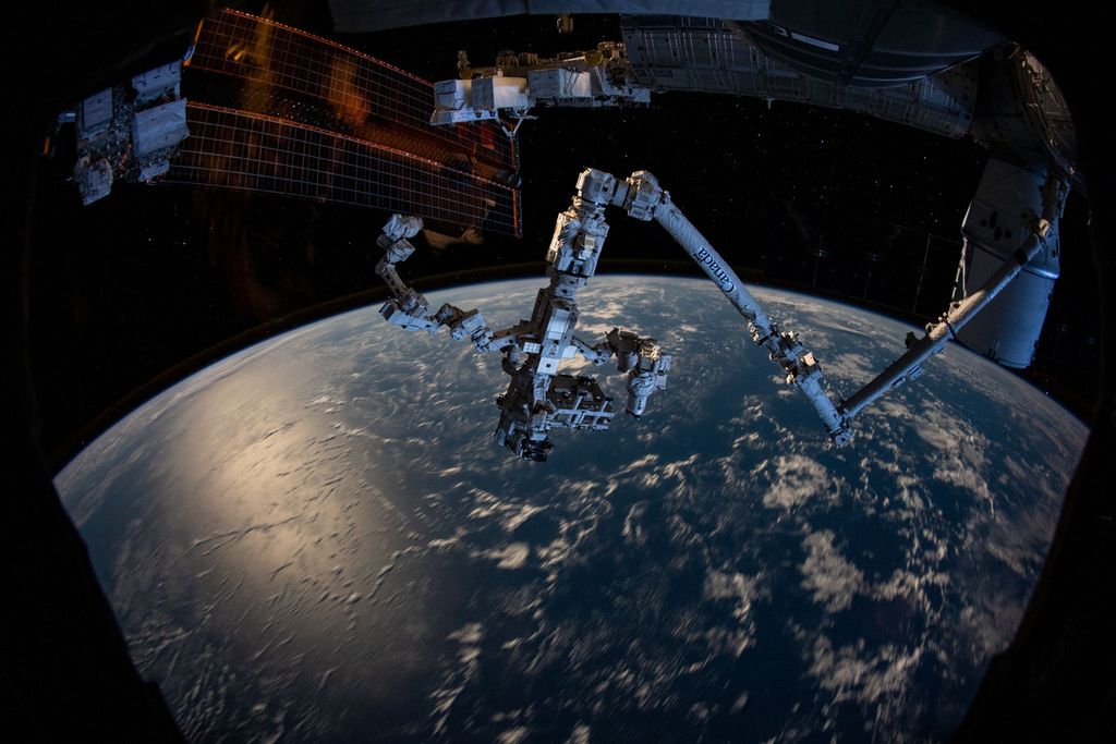 Lengan robot Canadarm2 dan tangan robot Dextre yang merupakan bagian dari Stasiun Luar Angkasa Internasional (ISS) dengan latar belakang lengkungan Bumi. Citra diambil saat ISS melintas di atas selatan Samudra Pasifik di ketinggian 423 kilometer pada 12 Desember 2019.