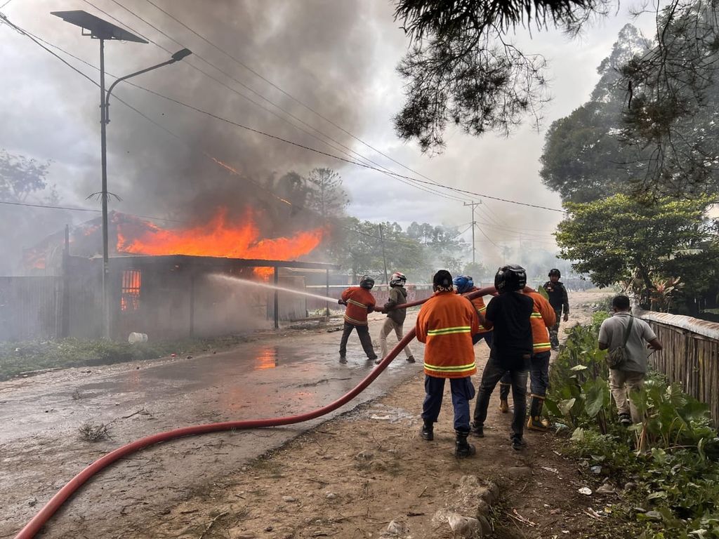 Tim pemadam kebakaran berupaya memadamkan api akibat aksi pembakaran sejumlah kios milik warga oleh sekelompok massa yang terpengaruh isu penculikan anak di Wamena, ibu kota Kabupaten Jayawijaya, Papua Pegunungan, Kamis (23/2/2023).