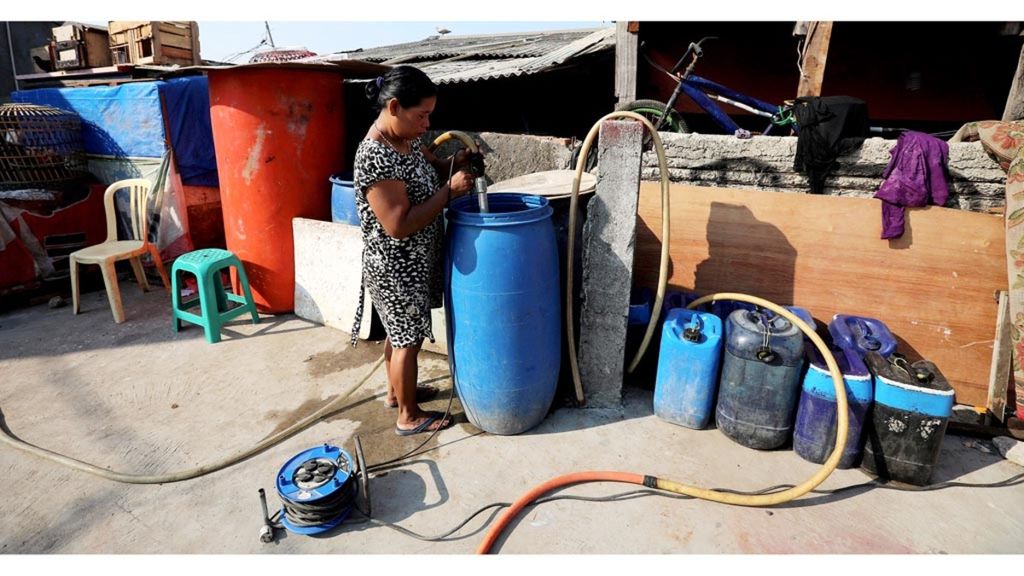 Kasni (43), pedagang air bersih di kawasan Muara Baru, Penjaringan, Jakarta Utara, menyalurkan air dari tandon besar ke rumah pelanggan melalui selang, Kamis (11/7/2019). Kebutuhan air bersih warga di sekitar kampung ini masih belum terjangkau pipanisasi air.