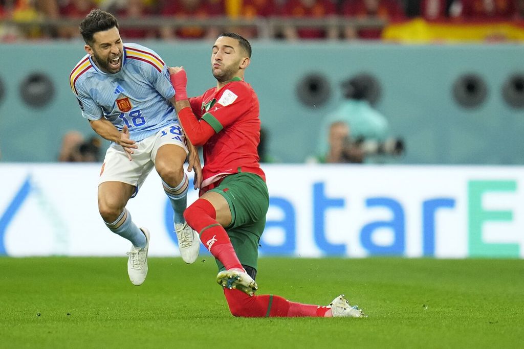 Spain's Jordi Alba, left, is fouled by Morocco's Hakim Ziyech during the World Cup round of 16 soccer match between Morocco and Spain, at the Education City Stadium in Al Rayyan, Qatar, Tuesday, Dec. 6, 2022. 