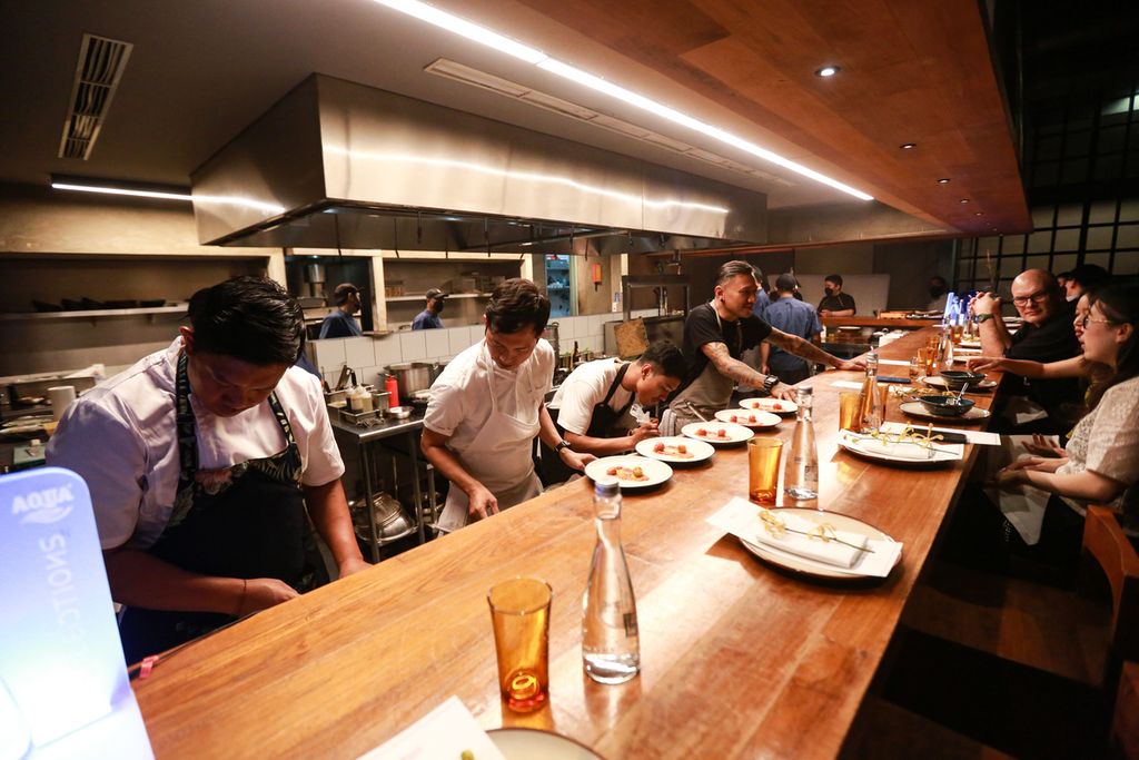 Suasana <i>open kitchen</i> ketika pengunjung dapat menyaksikan para <i>chef</i> mempersiapkan hidangan secara langsung dalam acara Kaum Santap Malam Series oleh tiga <i>chef </i>di Restoran Kaum Jakarta, Kamis (8/9/2022) malam.