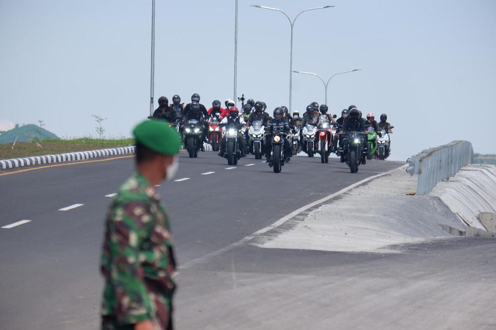 Presiden Joko Widodo yang menggunakan motor custom dari basic Kawasaki W175 dari Katros Garage, bersama rombongan melintas di Jalan Bypass Bandara Internasional Lombok-Mandalika saat kunjungan kerja ke Kawasan Ekonomi Khusus Mandalika, Pujut, Lombok Tengah, Nusa Tenggara Barat, Kamis (13/1/2022).