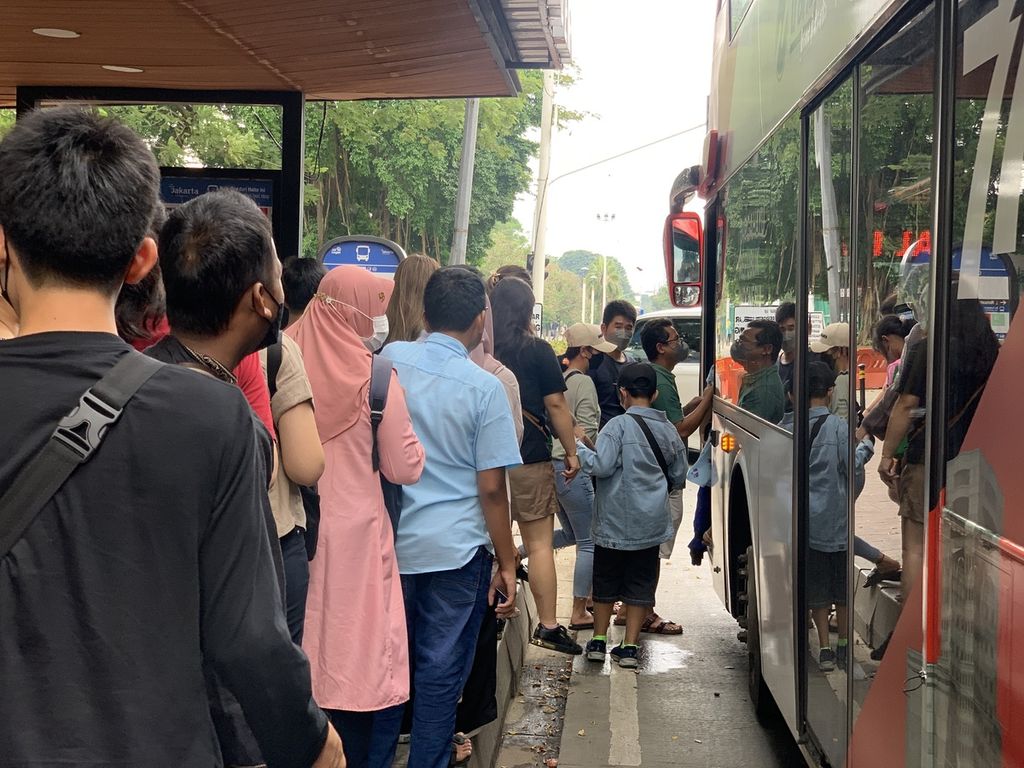 Masyarakat mengantre untuk naik ke bus wisata Transjakarta di Halte IRTI Monas, Jakarta, Sabtu (25/3/2023).