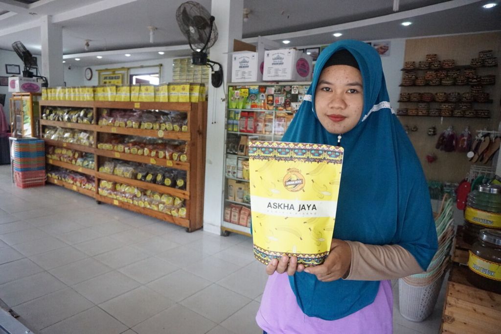 Karyawan toko oleh-oleh keripik pisang Askha Jaya di Bandar Lampung menunjukkan kemasan keripik, Rabu (30/1/2019). 