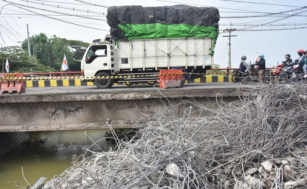 Truk melintasi ruas jalan tersisa dari Jembatan Ngaglik 1 yang ambles dan sedang dalam proses penghancuran di Kabupaten Lamongan, Jawa Timur, Rabu (30/3/2022). 