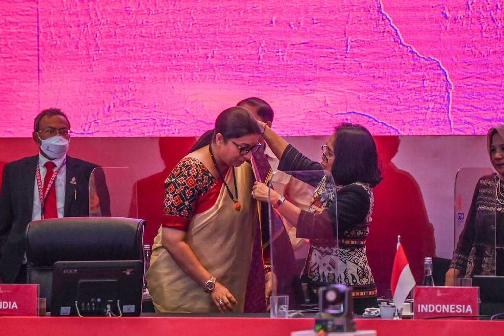 I Gusti Ayu Bintang Darmawati (kanan) melakukan serah terima presidensi G20 tentang pemberdayaan perempuan 2023 kepada Menteri Pembangunan Perempuan dan Anak India Smriti Zubin Irani dengan menyerahkan kain selendang dari Indonesia.