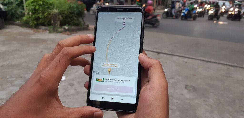 Pengguna tengah mengkases aplikasi TROB untuk memesan angkot daring berbasis aplikasi, Rabu (8/5/2019) sore, di Kota Bekasi, Jawa Barat.
