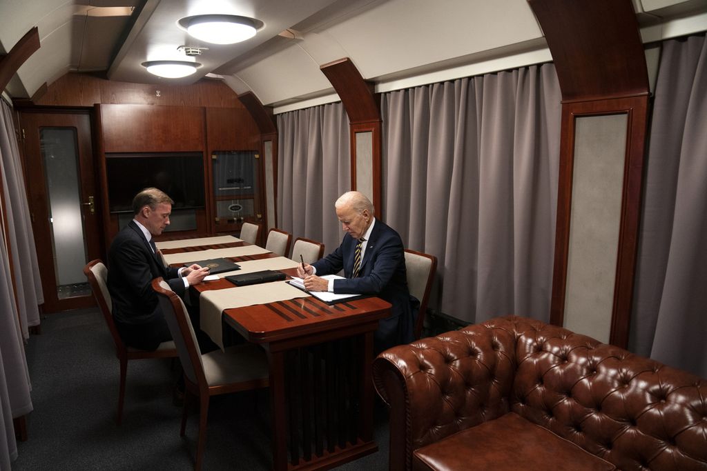 Presiden AS Joe Biden duduk di kereta bersama Penasihat Keamanan Nasional Jake Sullivan saat menyampaikan pidatonya menandai peringatan satu tahun perang di Ukraina setelah kunjungan mendadak untuk bertemu Presiden Ukraina Volodymyr Zelenskyy, Senin (20/2/2023), di Kyiv.