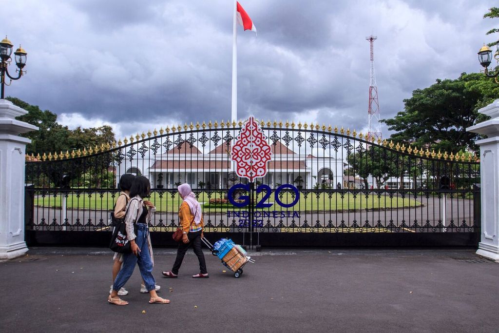 Warga berjalan di depan gerbang Istana Kepresidenan Yogyakarta, yang memajang logo G20 di Yogyakarta, 30 Oktober 2022. Sebagai Ketua G20 tahun ini, Indonesia akan menggelar KTT G20 di Bali, 15-16 November 2022. 