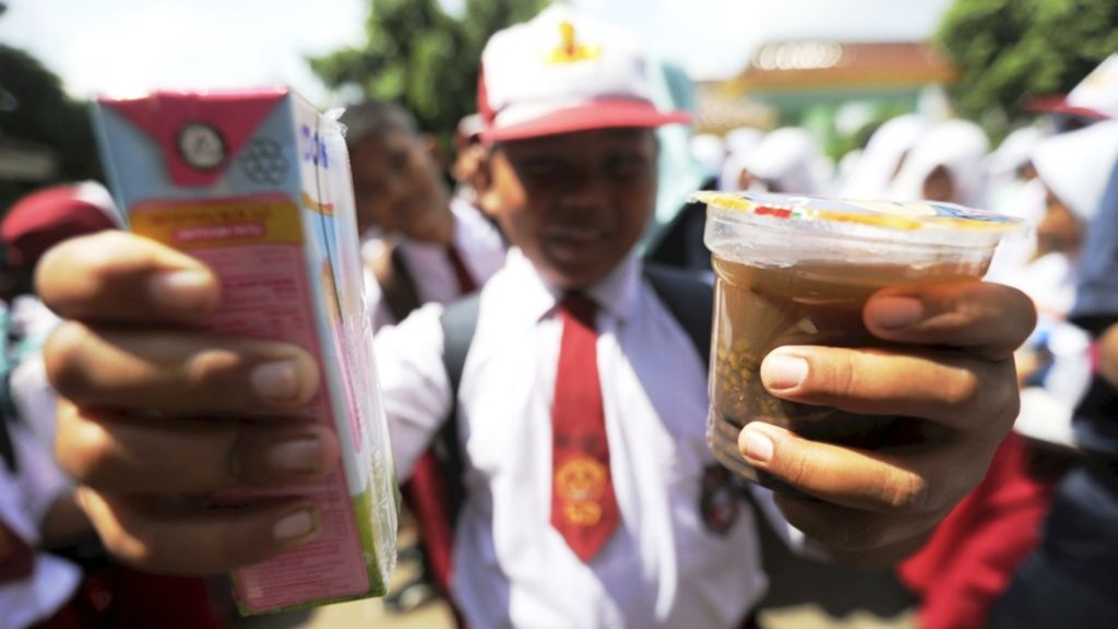 Murid SDN 03/05 Muara Angke, Penjaringan, Jakarta, menerima pembagian makanan tambahan untuk anak sekolah berupa susu UHT dan bubur kacang hijau, Senin (2/4/2018). Program pembagian makanan tambahan ini bertujuan untuk meningkatkan asupan gizi dan ketahanan fisik bagi murid sekolah.