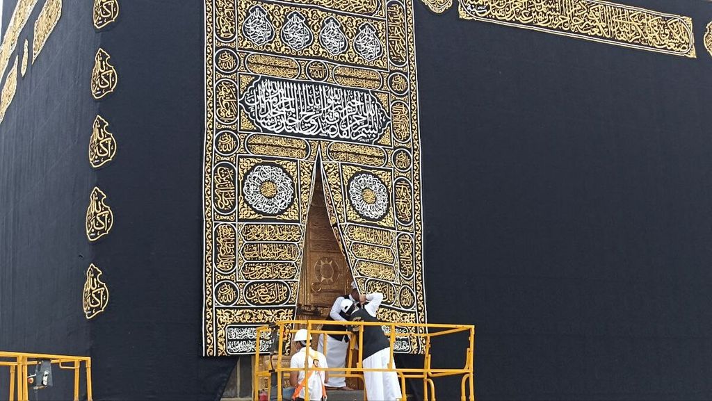 Para pekerja sedang merapikan kiswah atau kain penutup yang baru saja dipasang di Kabah di Masjidil Haram di Mekkah, Arab Saudi, pada  1 Muharam 1444 Hijriah, yang bertepatan dengan Sabtu (30/7/2022) pagi. Kiswah dibuat ratusan seniman dengan menggunakan bahan kain sutra, benang emas, dan perak. 