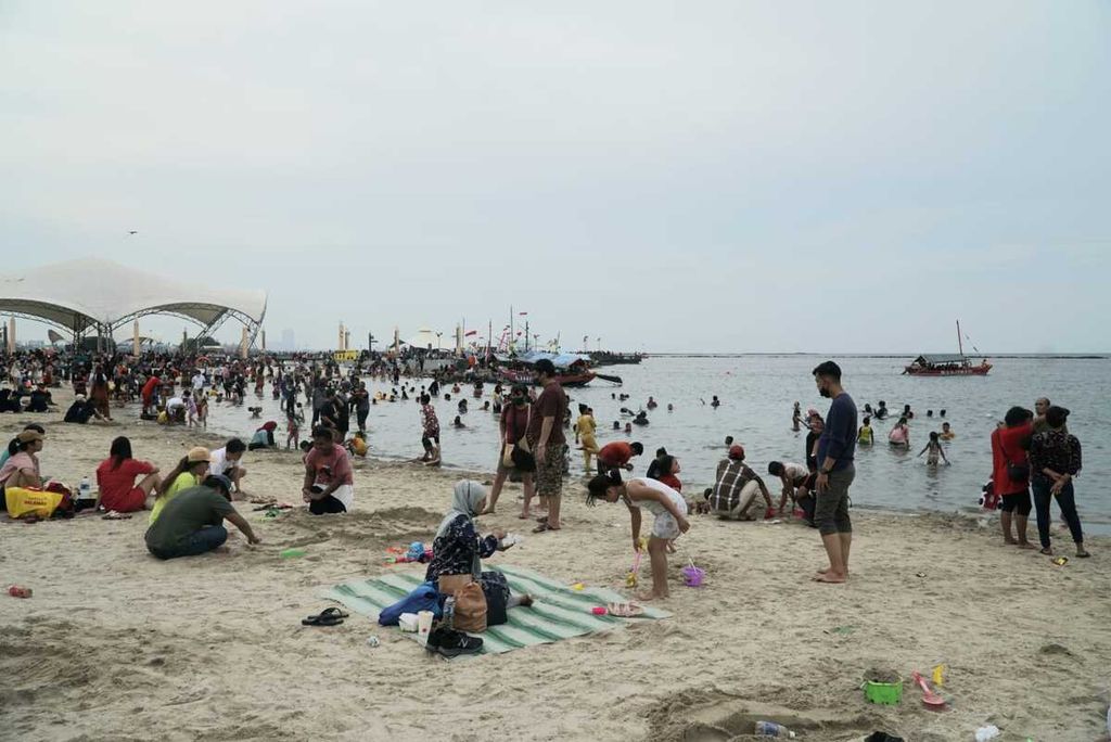 Wisatawan berekreasi di kawasan Pantai Lagoon Ancol, Taman Impian Jaya Ancol, Jakarta Utara, pada hari kedua Idul Fitri 1443 Hijriah, Selasa (3/5/2022). Pengelola menargetkan rata-rata 55.000 wisatawan berkunjung per hari saat momen libur Lebaran pada 2-15 Mei 2022.
