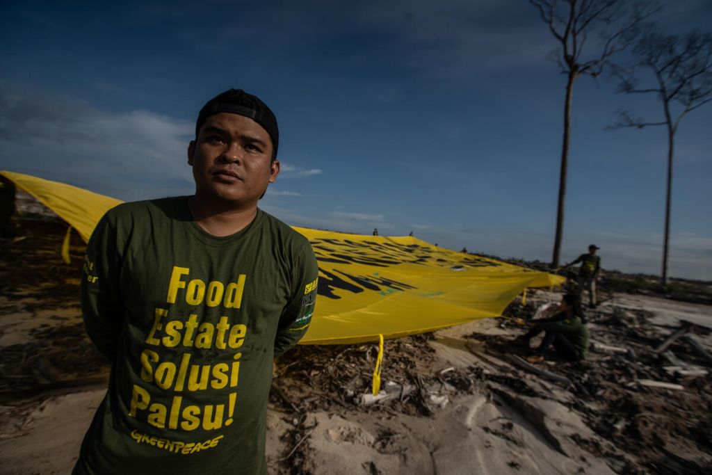 Seorang aktivis lingkungan menarik spanduk besar yang bertuliskan Food Estate Feeding Climate Crisis” di kawasan lumbung pangan (<i>food estate</i>) singkong di Desa Tewai Baru, Kabupaten Gunung Mas, Kalteng, Kamis (10/11/2022).