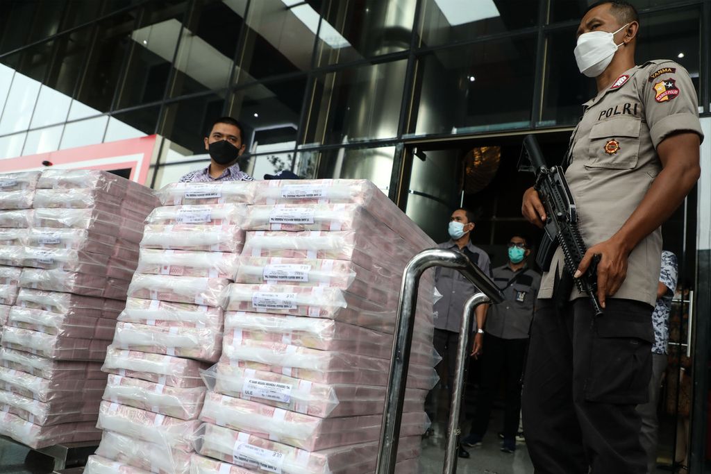 Petugas kepolisian mengawal ketat pemindahan uang Rp 52,3 miliar sitaan dari sebuah bank dalam kasus dugaan suap terkait izin ekspor benih lobster atau benur di Kementrian Kelautan dan Perikanan dari Gedung Komisi Pemberantasan Korupsi, Jakarta, menuju gudang penyimpanan, Senin (15/3/2021).