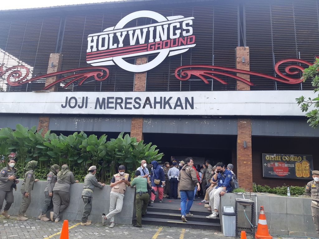 Petugas Sat Pol PP DKI Jakarta saat menutup Holywings Tanjung Duren, Jakarta Barat, Selasa (28/6/2022) pagi.
