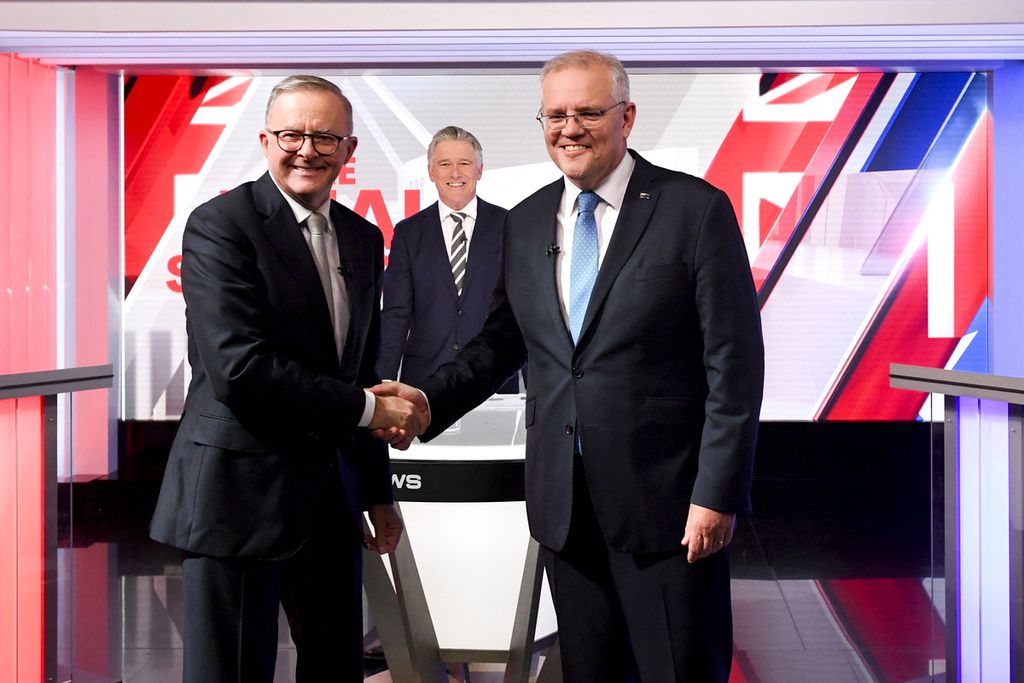Perdana Menteri Australia Scott Morrison (kanan) dan pemimpin oposisi Anthony Albanese berjabat tangan dalam acara debat terakhir pemilu 2022 di Sydney, 11 Mei 2022. 