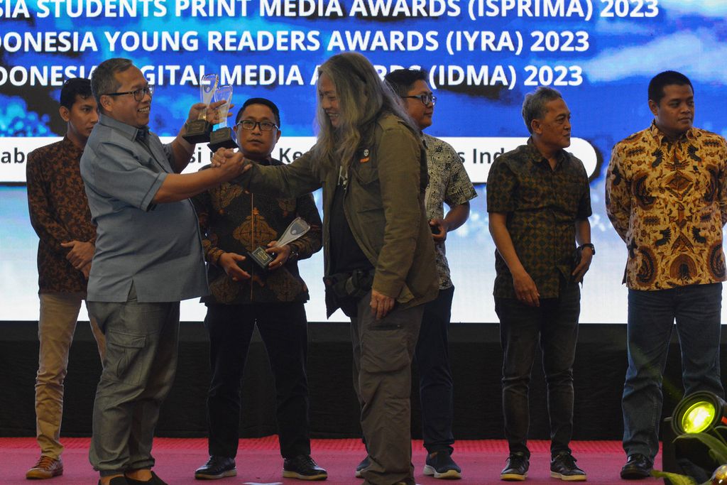 Wakil Pemimpin Redaksi Harian <i>Kompas</i> Tri Agung Kristanto (kiri) bersalaman dengan salah satu anggota dewan juri Oscar Motuloh pada acara Serikat Perusahaan Pers (SPS) Awards di Hotel Merlyn Park, Jakarta Pusat, Senin (20/3/2023). Harian <i>Kompas</i> mendapatkan enam penghargaan dengan rincian tiga <i>gold winner</i> dan tiga <i>silver winner</i>.