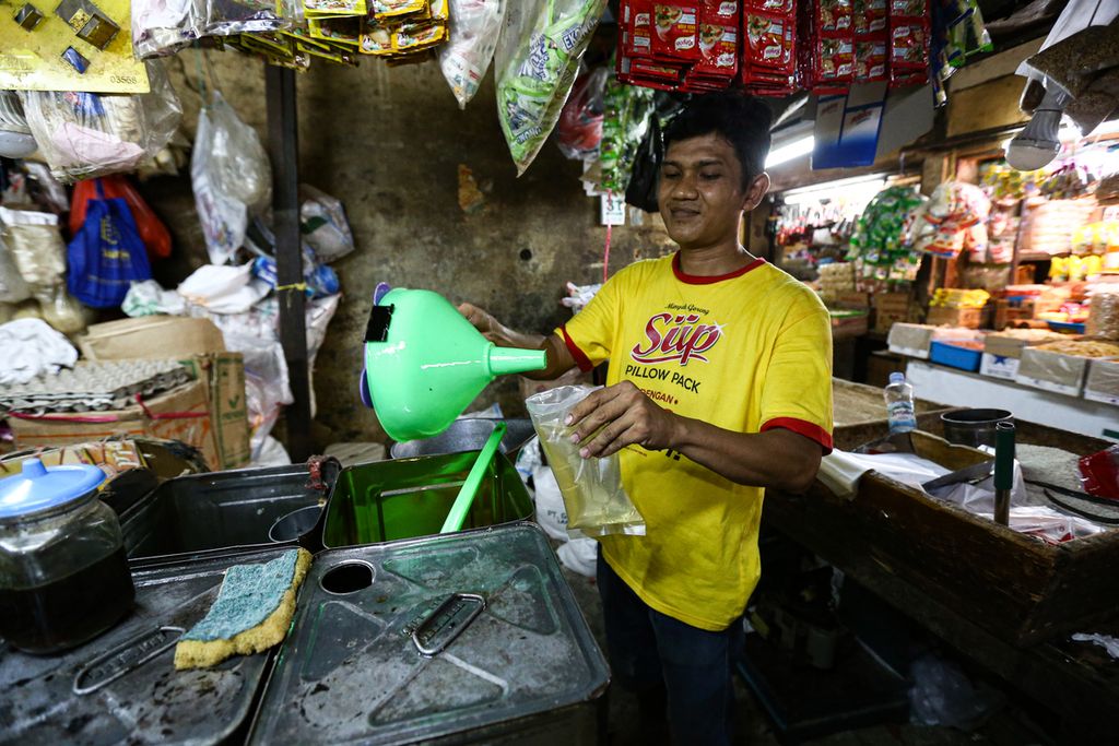 Seorang pedagang mengemas minyak goreng curah di pasar Kebayoran Lama, Jakarta Selatan, Senin (30/1/2022). Minyak goreng curah dijual di pasar tersebut dengan harga Rp 20.000 per kilogram.