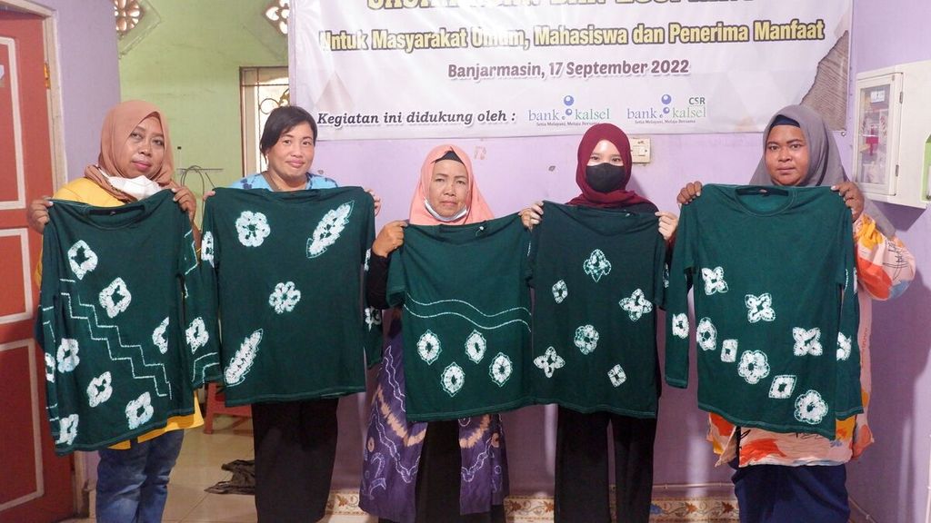 Warga memperlihatkan kaus sasirangan yang sudah jadi dalam kegiatan lokakarya pembuatan sasirangan dan <i>ecoprint </i>di Rumah Kreatif dan Pintar, Kelurahan Basirih Selatan, Banjarmasin Selatan, Kota Banjarmasin, Kalimantan Selatan, Sabtu (17/9/2022).
