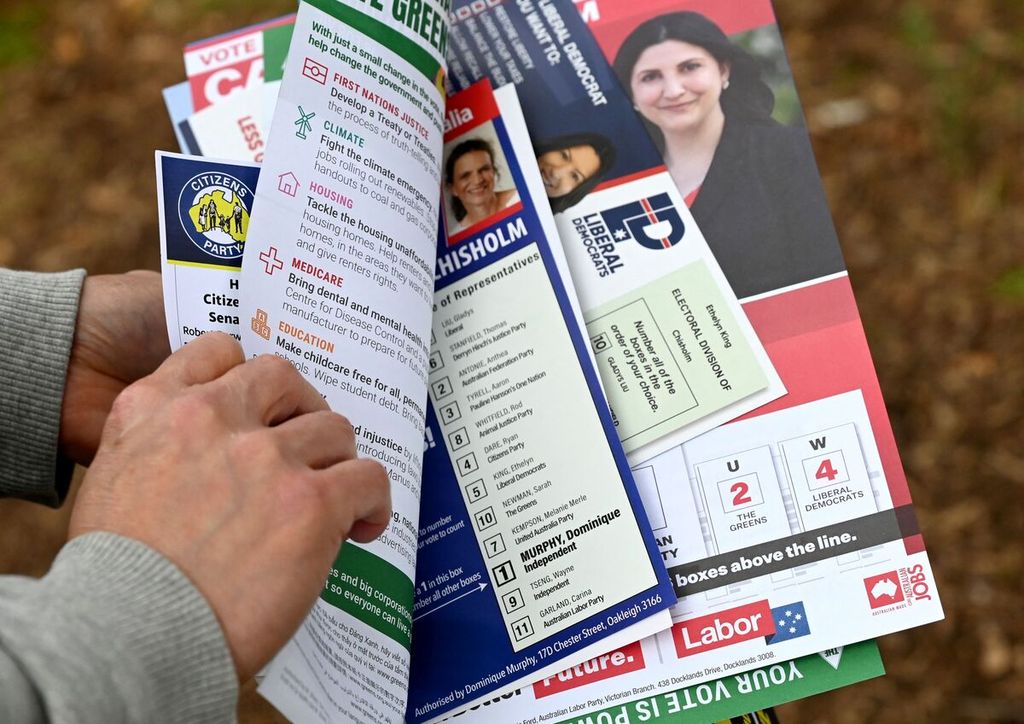 Seorang pira memegang pamflet kampanye calon-calon anggota parlemen Australia di daerah pemilihan Chisholm di Melbourne pada 19 Mei 2022. Pemungutan suara untuk pemilihan umum parlemen Australia digelar 21 Mei. 