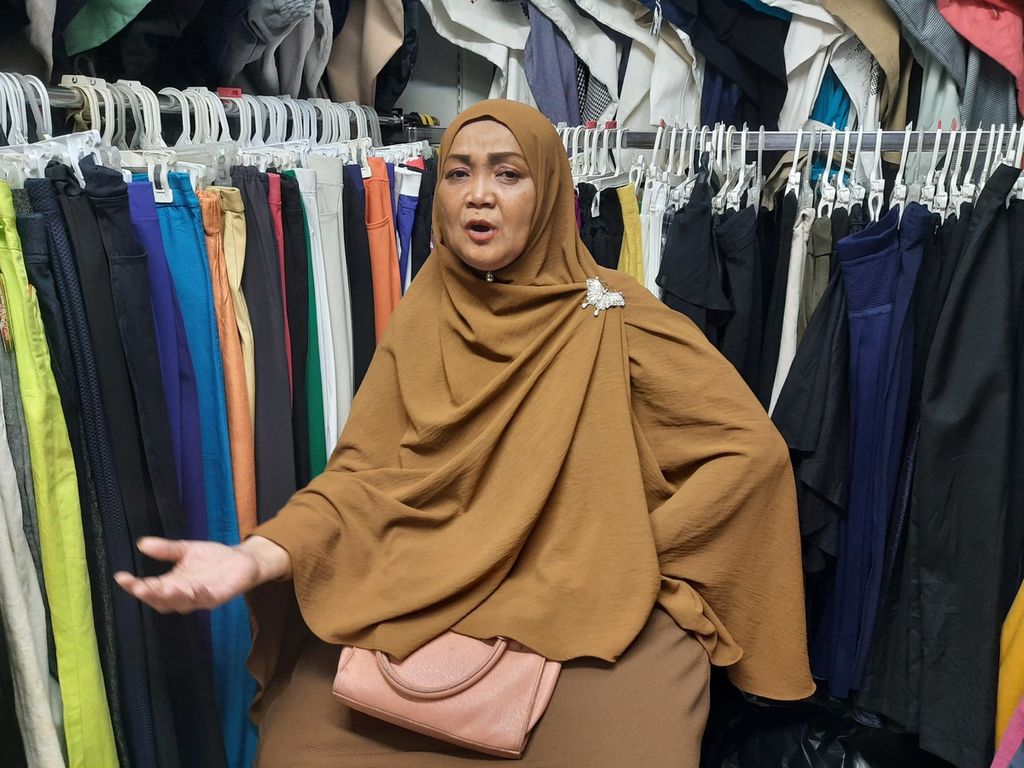 Pedagang pakaian impor bekas, Ana (55), saat berdagang di Pasar Senen, Jakarta, Sabtu (1/4/2023). Ia fokus menghabiskan stok barang-barang yang tersisa meski belum memiliki rencana selanjutnya setelah pakaian-pakaian habis terjual.
