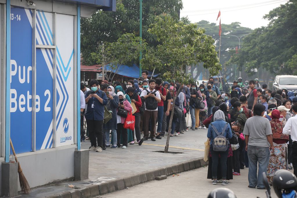 Warga antre di Halte Puri Beta, Tangerang, Banten, Senin (13/3/2020) sekitar pukul 08.00. Sejumlah trayek angkutan publik di Kota Jakarta dan sekitarnya dibatasi jumlahnya sebagai langkah meminimalisasi penularan Covid-19.