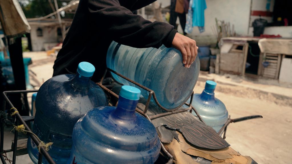 Pekerja menata galon air kemasan berbahan polikarbonat di Cilincing, Jakarta Utara, Rabu (21/9/2022).  