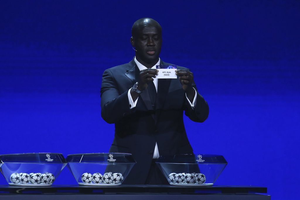 Mantan pemain Pantai Gading, Yaya Toure, menunjukkan kertas bertuliskan tim Ajax saat acara undian fase grup Liga Champions 2022-2023 di Istanbul, Turki, Jumat (26/8/2022) dini hari WIB. 