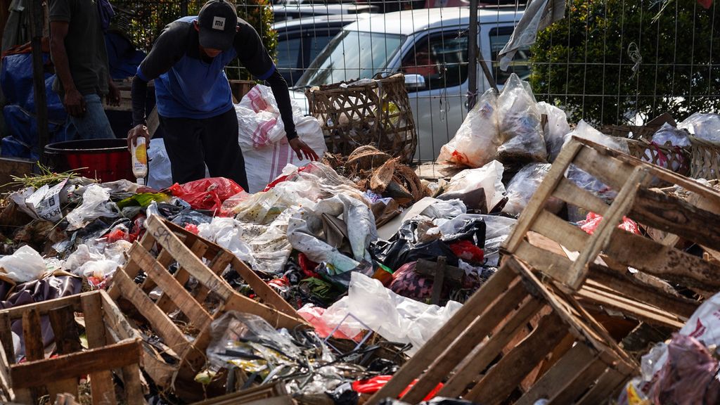 Seorang warga membuang sampah di tempat pembuangan sampah sementara di kawasan Pasar Anyar, Kota Bogor, Sabtu (28/8/2021). 