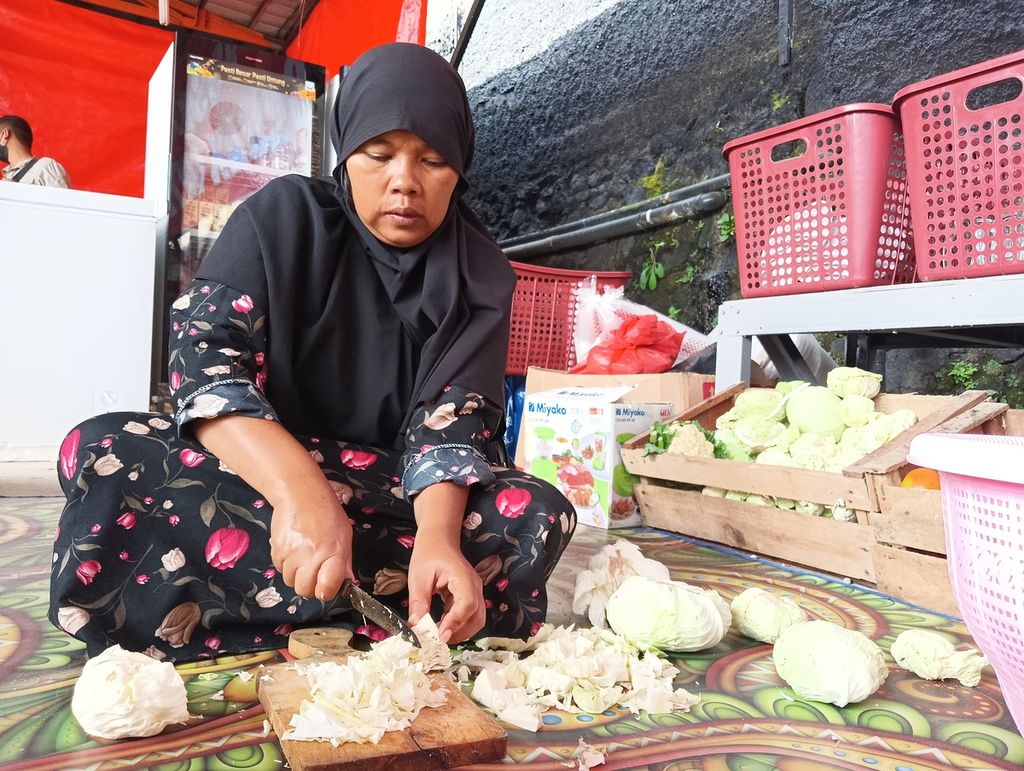 Titi (45), warga Kampung Cimanglid, Desa Cijedil, Cugenang, membantu memasak di dapur umum posko pengungsian Badan Intelijen Negara (BIN), Kamis (8/12/2022). 