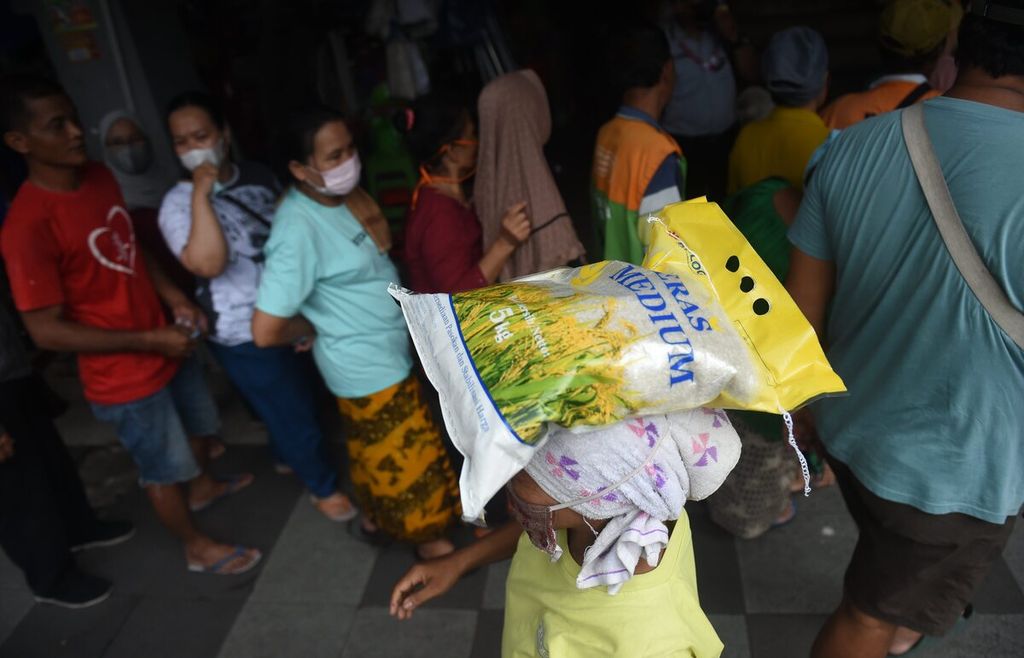 Pedagang membawa beras medium yang dibeli saat Operasi Pasar Beras di Pasar Genteng Baru, Surabaya, Jawa Timur, Kamis (9/2/2023). 