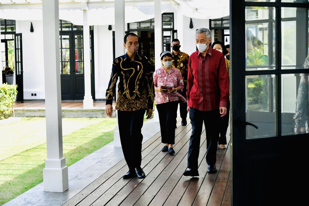 Presiden Joko Widodo dan Perdana Menteri Singapura Lee Hsien Loong berjalan menuju ruang pertemuan di Bintan, Kepulauan Riau, 25 Januari 2022. 