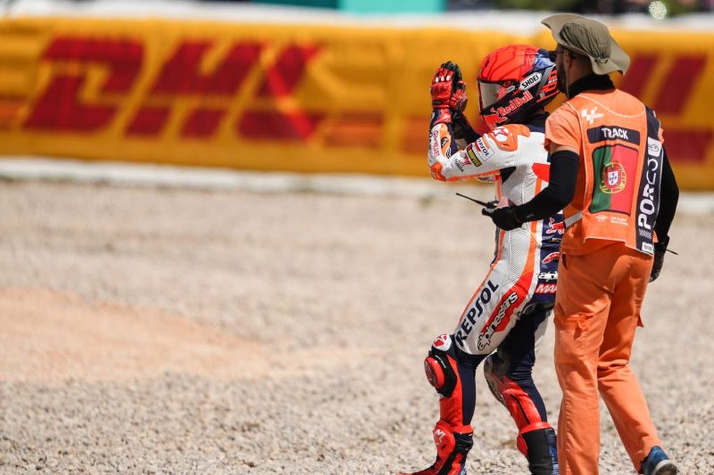 Pebalap tim Repsol Honda Marc Marquez dikawal oleh marshal setelah mengalami kecelakaan di mana motornya menabrak pebalap RNF Racing Miguel Oliveira di tikungan 3 Sirkuit Internasional Algarve, Portimao, Portugal, dalam balapan pembuka MotoGP 2023, Minggu (26/3).