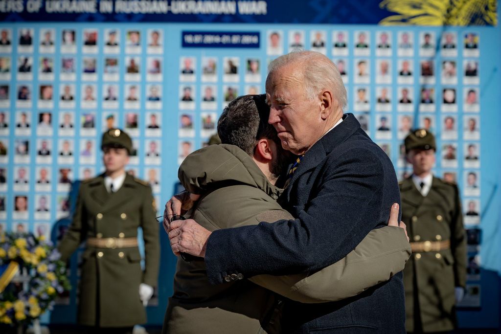 Presiden AS Joe Biden (kanan) dan Presiden Ukraina Volodymyr Zelenskyy berpelukan saat keduanya akan berpisah di Tembok Peringatan Pembela Ukraina yang gugur dalam perang Rusia-Ukraina di Kyiv,  Senin (20/2/2023). 