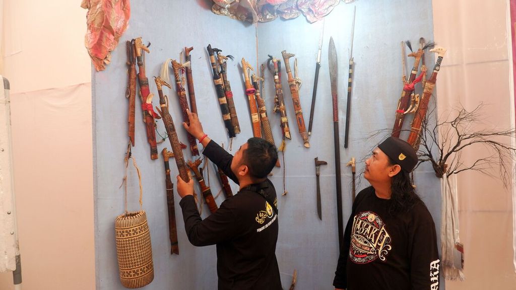 Penjaga stan memperlihatkan berbagai macam mandau, senjata etnik Dayak Kalimantan, yang dipajang dalam kegiatan Pameran Temporer di Museum Wasaka, Banjarmasin, Kalimantan Selatan, Jumat (14/10/2022). 
