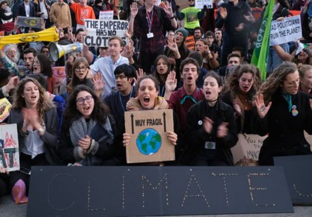 Pengunjuk rasa melakukan aksi di depan tempat pertemuan Konvensi Kerangka Kerja Perubahan Iklim Perserikatan Bangsa-Bangsa (UNFCCC) COP 25 pada hari terakhir konferensi di Madrid, Spanyol, pada Jumat (13/12/2019). Mereka mengkritik para delegasi yang dianggap gagal menyepakati mekanisme untuk meningkatkan penurunan emisi global dan mengantisipasi dampak perubahan iklim yang sudah terjadi. 