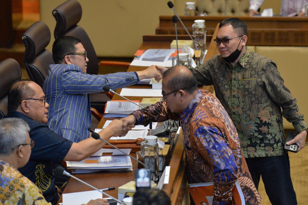 Deputy Chairman of Commission II DPR RI Junimart Girsang (left from below) shakes hands with KPU Chairman Hasyim Asy'ari at the DPR Commission II building, Monday (6/1/2023).