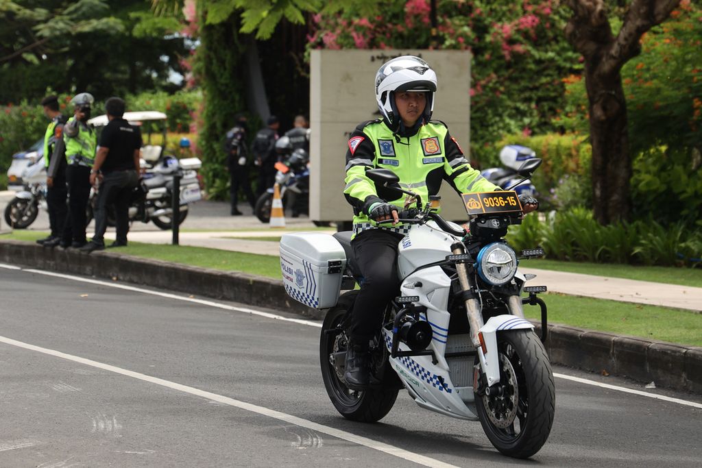 Police ride an electric motorbike in front of the Apurva Kempinski Hotel, Nusa Dua, Bali. 