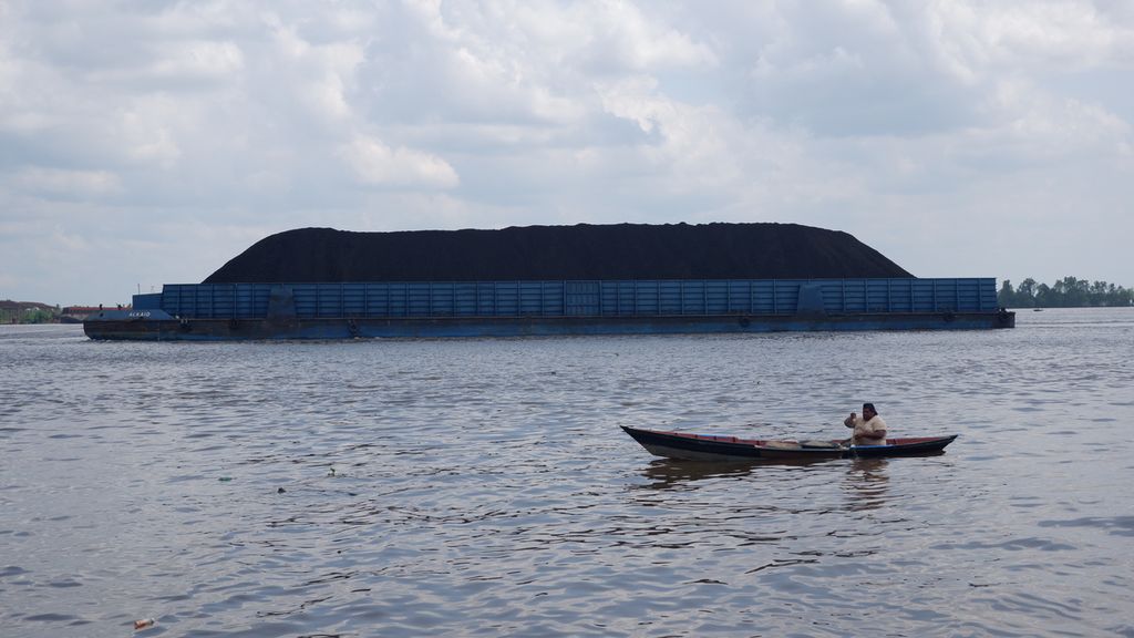 Tongkang bermuatan batubara melintasi Sungai Barito di Kota Banjarmasin, Kalimantan Selatan. Foto diambil Agustus 2019.