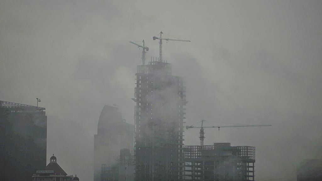  Kabut tipis menyelimuti proyek pembangunan apartemen di kawasan selatan Jakarta, Selasa (21/2).