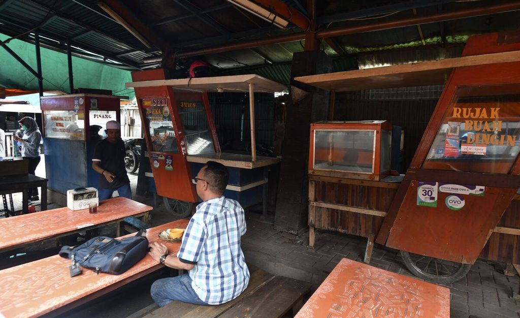 Pekerja menikmati makan siang saat jam istirahat kantor di salah satu sentra warung makan kaki lima di dekat perkantoran Jalan Karet Pasar Baru Timur, Jakarta Pusat, Senin (23/3/2020).
