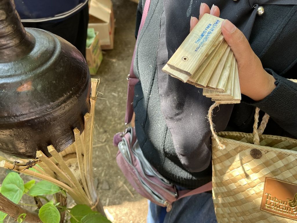Seorang pengunjung di Pasar Barongan Kali Gunting di Desa Mojotrisno, Kecamatan Mojoagung, Kabupaten Jombang, Sabtu (6/8/2022), hendak berbelanja dengan memakai alat tukar uang dari bambu.