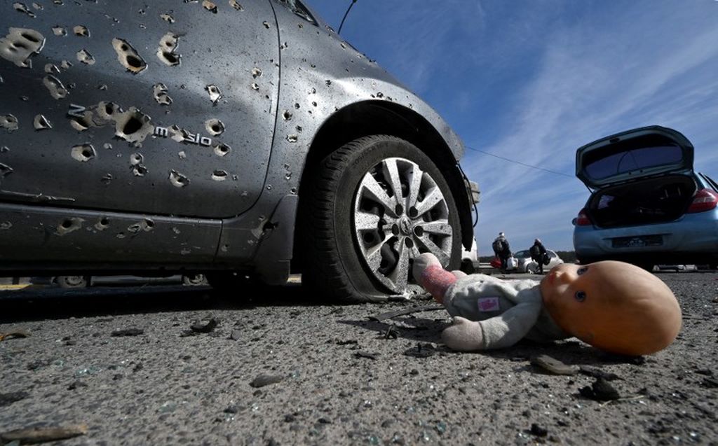 Sebuah boneka ditinggalkan di samping mobil yang dipenuhi bekas berondongan peluru di Irpin, utara Kiev, Ukraina, pada 12 Maret 2022.
